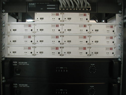Vista frontal, mostrando o material de distribui&ccedil;&atilde;o de audio via IP e o de amplifica&ccedil;&atilde;o, contendo internamente m&oacute;dulos de supervis&atilde;o.